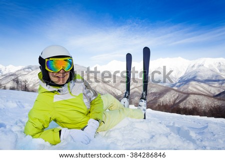 Skier woman lay in snow with ski and turn back