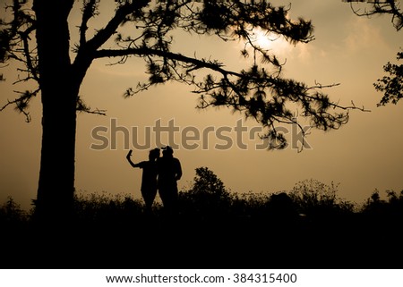 couple silhouette  with sunrise under the tree,customize colors ,Phu Rua national park,Loei province,Thailand