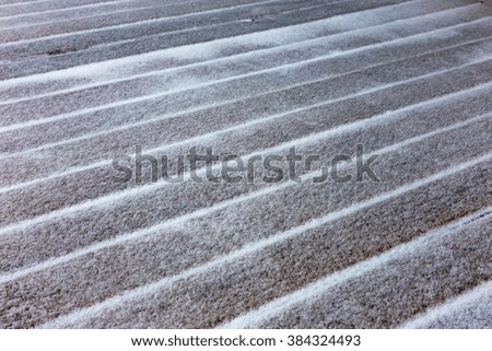 Old wooden boards under a thin snow with a blank space for vstaki object. Beautiful horizontal rhythmic background for winter design. Soft focus