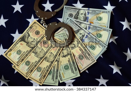 handcuffs on money background and american flag