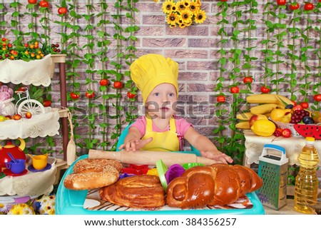 adorable baby cooking in kitchen. little cute child in costume of Cook. Pretty beautiful boy covered in flour makes cakes.Little baby girl is cooking, kneads dough baking, pastry rolls out