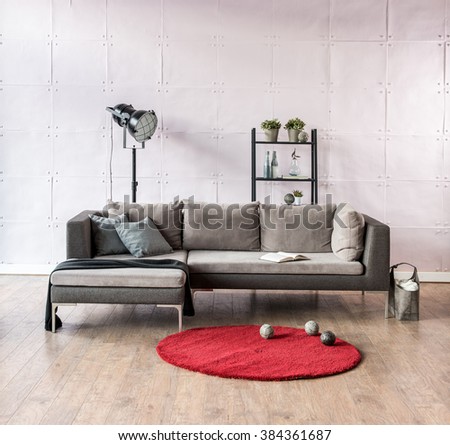 modern living room corner sofa behind stone soft wall and black lamp with red carpet 