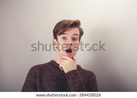 insulted shocked, surprised young man, in disbelief isolated grey background.