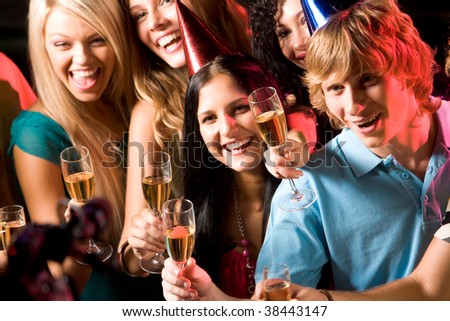 Image of people with hats holding glasses of champagne