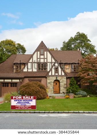 Real estate for sale open house (let us help you buy sell your next home) welcome sign Beautiful Tudor Style Suburban Home Residential Neighborhood Blue Sky Clouds USA