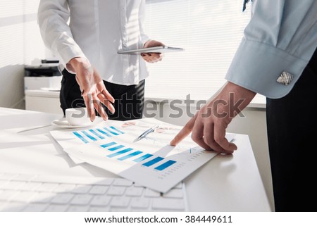 Image of male hand pointing at business document during discussion at meeting

