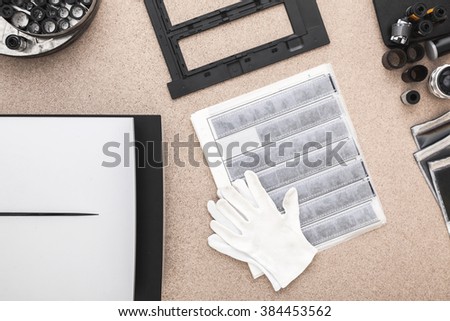 Phtographer's desk. Negative scanner, white gloves, contact sheets.