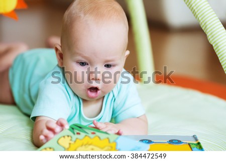 Adorable baby looking a book 