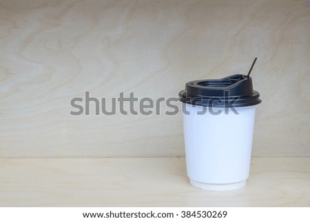 Paper coffee cup on wooden background