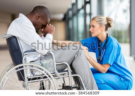 caring middle aged doctor comforting a disabled patient 