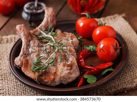 Grilled juicy steak on the bone with vegetables on a dark wooden background