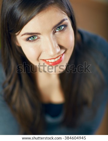 Close up face portrait of toothy smiling young woman looking up. Beautiful eyes. Long hair.