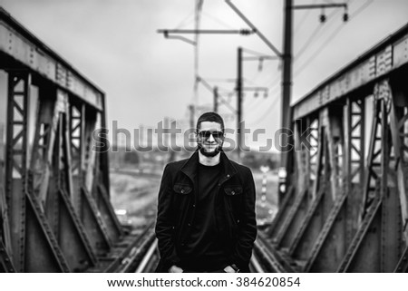 Young man with beard walking on the railway