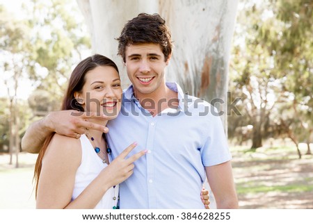 Young couple in the park celebrating