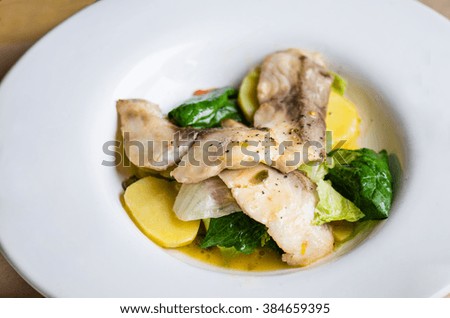 Fish fried with vegetables - perfect dinner or lunch. Living a healthy home-cooked meal . Close-up in white plate on the table.
