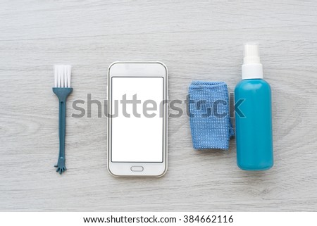 Smart phone and cleaing set on gray background.