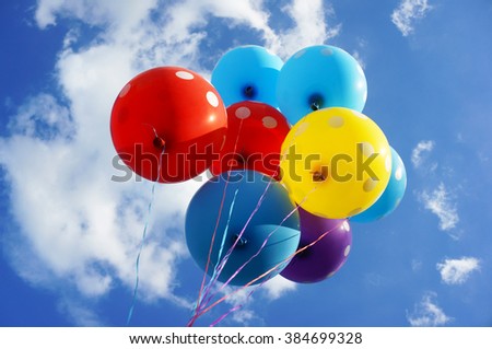 Colorful balloons against sunny blue sky. 