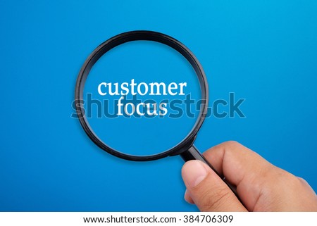 Customer focus, business concepts. Hand holding magnifying glass focusing on the words.
