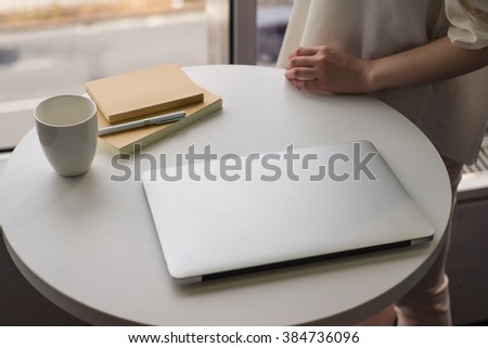 laptop cup book on the table