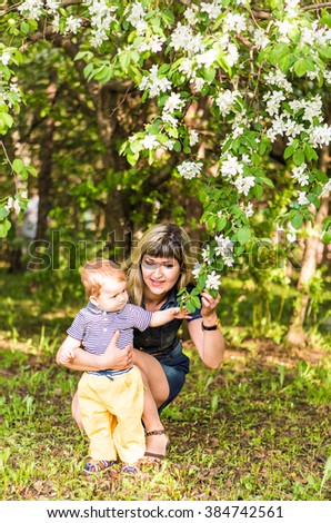 Happy woman and child in beautiful spring blooming garden. Family holiday concept. Mothers day