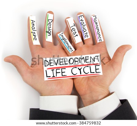Photo of hands holding paper cards with DEVELOPMENT LIFE CYCLE concept words