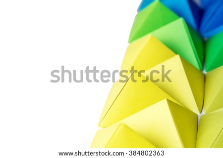Creative abstract background with blue, green and yellow origami pyramids with free copy space on the left side. Great for using in web.