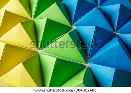 Futuristic background with blue, green and yellow origami pyramids is great for using in web.