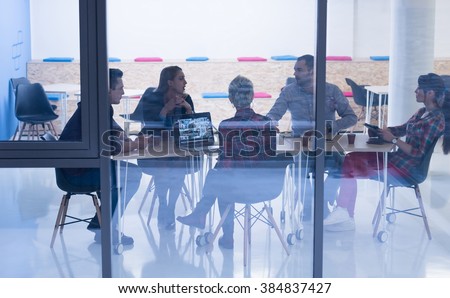 startup business team on meeting in modern bright office interior brainstorming, working on laptop and tablet computer Royalty-Free Stock Photo #384837427