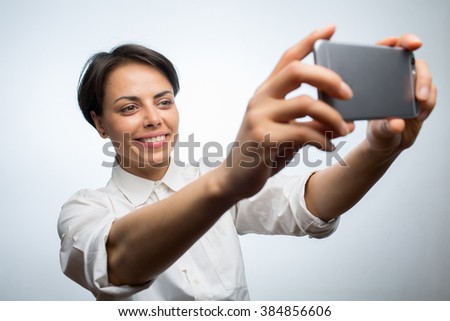 Color picture of an attractive young woman taking a selfie with a smartphone