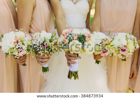 Bride and bridesmaids hand with beautiful flowers Royalty-Free Stock Photo #384873934