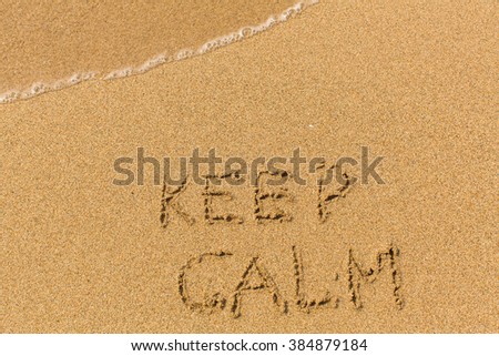 Keep Calm -  drawn on the sand beach with the soft wave.  