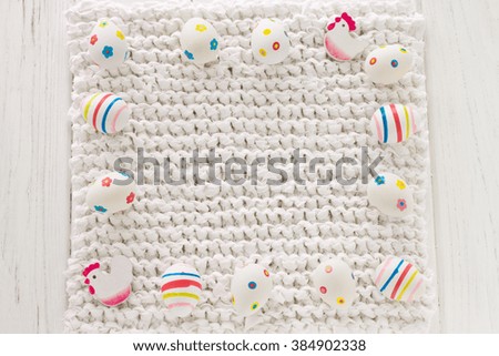 Frame of easter eggs on a white knitted tablecloth