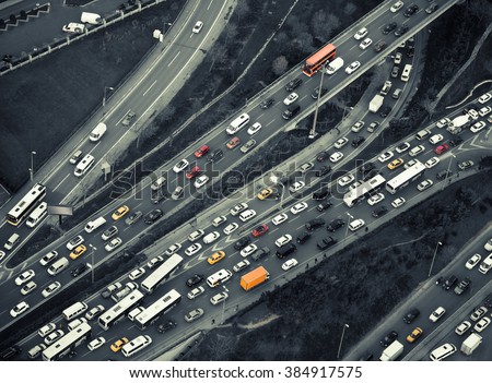 Urban transportation - rush hour traffic on a city roads. Modern metropolis with intersection of the traffic trails on a highway. Traffic jams of roadside, transportation motion in a big city. Royalty-Free Stock Photo #384917575