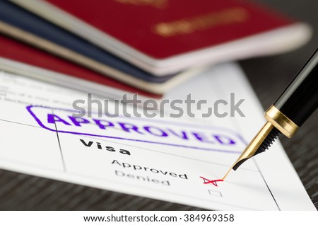 Visa form close up, fountain pen and approved stamped on a document. Royalty-Free Stock Photo #384969358