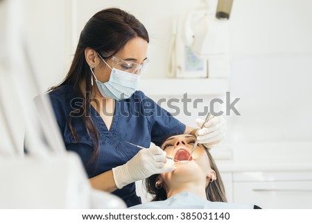 Dentists with a patient during a dental intervention. Medical Concept. Royalty-Free Stock Photo #385031140