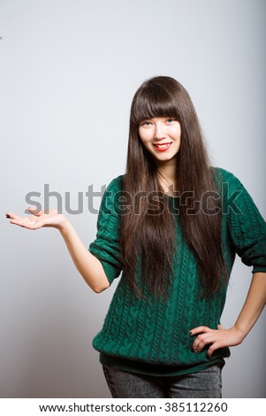 long-haired girl holding something invisible on the palms, business woman isolated on a gray background