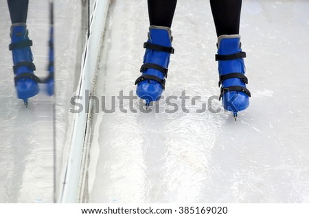 Ice skating on the skating rink in blue ice skates.