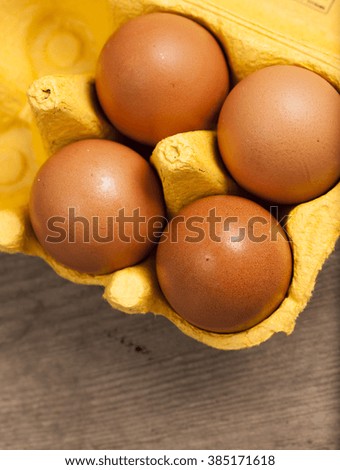  Yellow cardboard egg box on wooden table . Top view