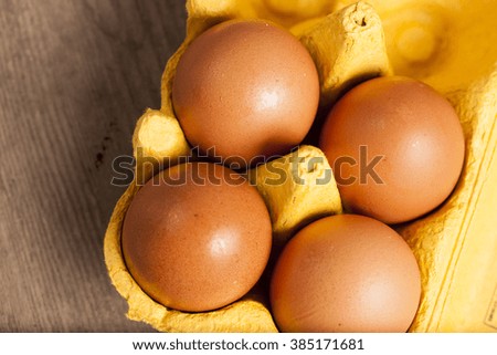  Yellow cardboard egg box on wooden table . Top view