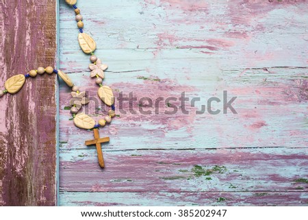 Crucifix and flower necklace wooden background with empty space for message and photos