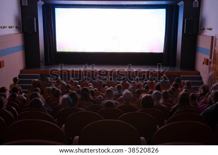 Cinema auditorium with people in chairs watching movie performance. Ready for adding your own picture.