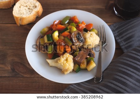 Cooked vegetables mix on white plate on a wooden background

