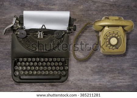 Vintage typewriter, telephone on wood