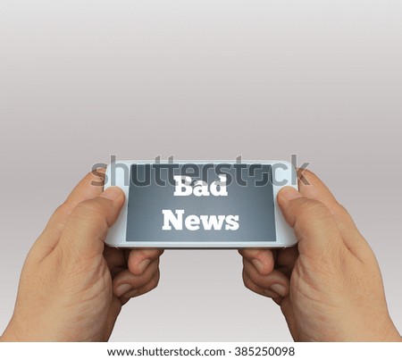 a man using hand holding the smartphone with text Bad News on display