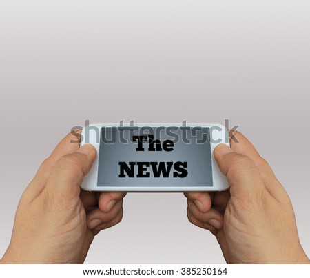 a man using hand holding the smartphone with text The News on display