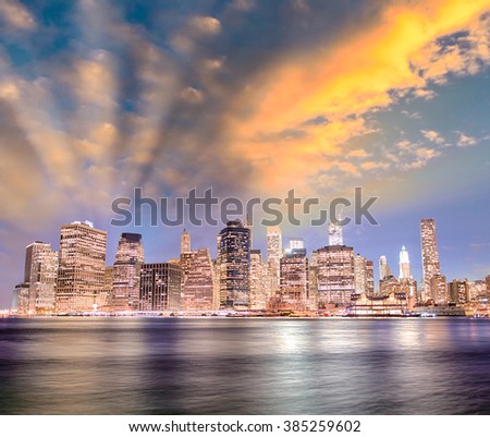 Stunning sunset in New York City. Lower Manhattan night skyline from Brooklyn Bridge Park.