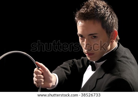 young magician with silver metal rings on black background