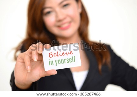 believe in yourself, motivate message on the card shown by a pretty business woman
