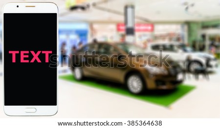 Mobile phone, blur image of car sales showroom as background.