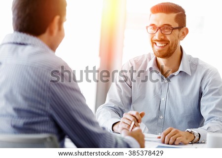 Attractive office worker sitting at desk Royalty-Free Stock Photo #385378429